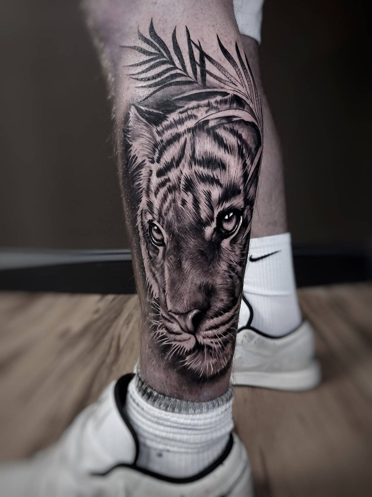 Black and grey realism calf tattoo of a tiger's face